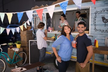 Happy couple standing with juice