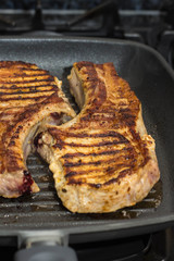 Steak of Large piece of pork meat with rib prepared on a grill pan