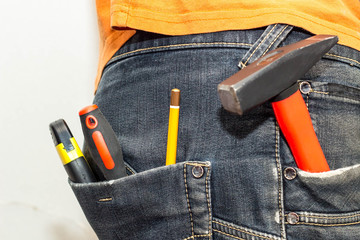 Engineering work tool in the back pocket of the jeans. pencil screwdriver hammer and utility knife