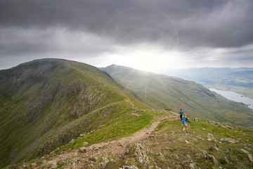 Two hikers walking along Swirl Band towards the summit of the Old Man of Coniston in the English...