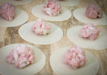 Raw dumplings, minced meat and dough on table