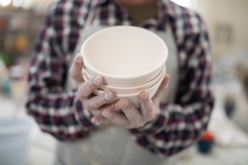 Proud male potter showing his creation to camera close up
