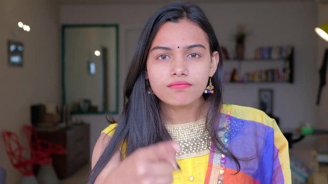 Serious and stern warning by a beautiful bride in colorful dress looking straight at the camera pov 