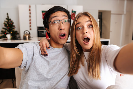 Cheerful young couple sitting on a couch at home