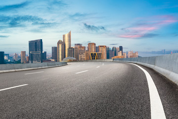 Empty asphalt road and city skyline at sunrise in hangzhou