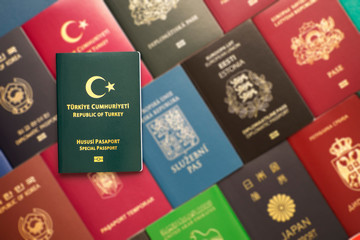 Green special biometric passport of Turkey on a blurred background of various documents of many countries of the world