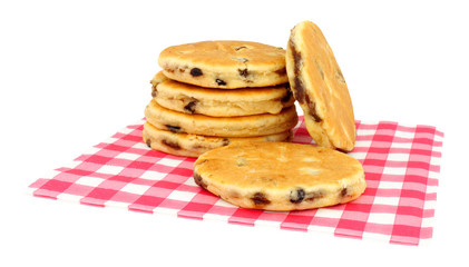 Traditional fruit Welsh cakes on red gingham pattern paper napkin isolated on a white background