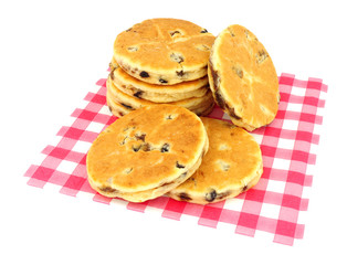 Traditional fruit Welsh cakes on red gingham pattern paper napkin isolated on a white background
