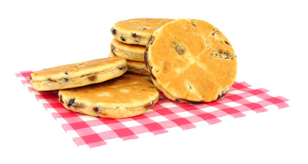 Traditional fruit Welsh cakes on red gingham pattern paper napkin isolated on a white background