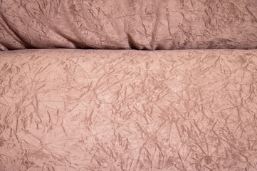 A close-up of a fragment of an expensive beige textile sofa in the room