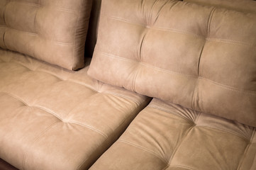 A close-up of a fragment of an expensive beige textile sofa in the room