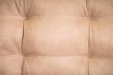 A close-up of a fragment of an expensive beige textile sofa in the room