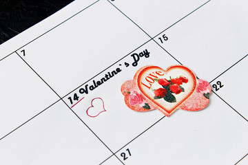 Calendar page with red hearts on February 14, Valentine's Day on a black background. Valentines day greeting card