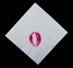 Folded white paper napkin with lipstick lips on it