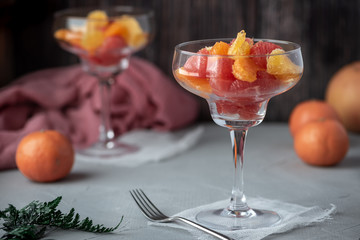Citrus Salad. Grapefruit, mandarin and orange in a glass on a dark background.
