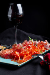 assorted cold meat, prosciutto, slices ham, beef jerky, salami, meat and mustard on black...