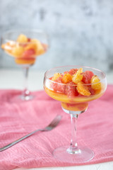 Salad of citrus and honey. Grapefruit, mandarin and orange in a glass on a dark background.