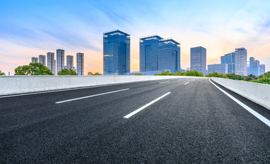 Asphalt road and modern city commercial building in Shanghai at dusk