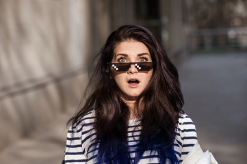 Amazed brunette woman in cartoon sunglasses outdoors