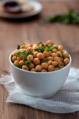 Cooked chickpeas with parsley and paprika in a white bowl. Vegetarian food.