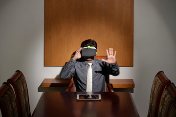 Entrepreneur in VR headset using invisible interface in front of him
