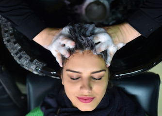 young woman in hairdresser salon washing hair