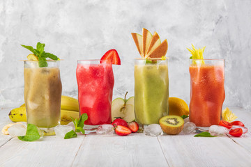 smoothies with fruit on a white wooden backdrop
