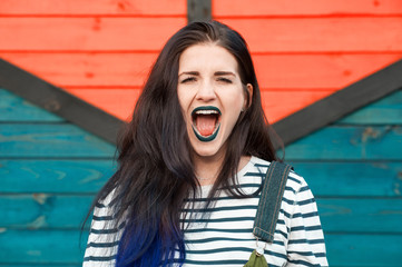 Screaming affective woman with dark make-up on bright background