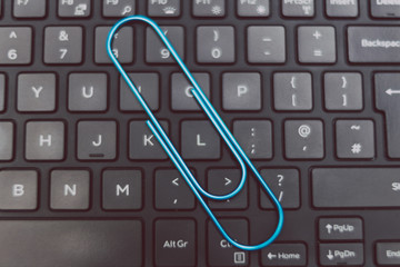 laptop keyboard with clip symbol of email attachments