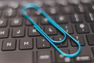 laptop keyboard with clip symbol of email attachments