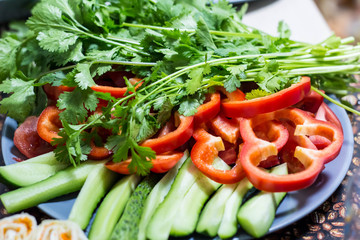 Cut cucumbers and tomatoes pepper parsley on table