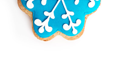 Cookie in a shape of blue snowflake with bite, isolated on white. Christmas holiday decoration, winter time food background.