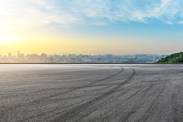 Panoramic city skyline and buildings with empty asphalt road at sunrise