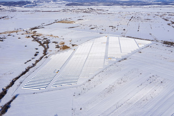 Aerial image of snow covered solar panel park