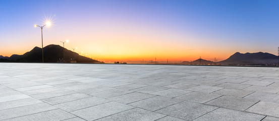 Empty square floor and mountain silhouette at beautiful sunset
