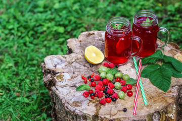 Juice of fresh raspberries served with ice in a glass On wooden stump. Top view