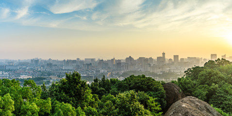 Modern city skyline and mountain scenery at sunrise