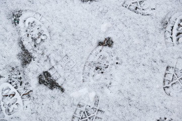 traces of shoes on white snow, top view