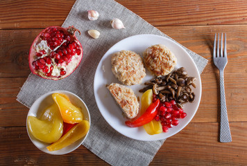 meatballs with rice mushrooms, sweet peppers and pomegranate seeds on brown wooden background.