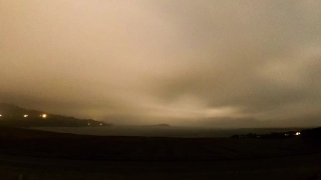 Time lapse of the rare atmospheric phenomena of a lunar rainbow - Moonbow - at night, Staffin Bay on the Isle of Skye, Scotland