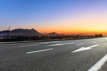 Empty asphalt road and mountains at beautiful sunset
