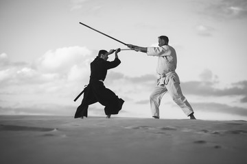 Concentrated men, in Japanese clothes, are practicing martial arts
