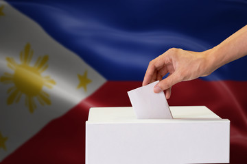Close-up of human hand casting and inserting a vote and choosing and making a decision what he...