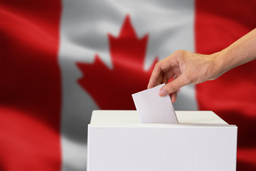Close-up of human hand casting and inserting a vote and choosing and making a decision what he...