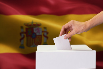 Close-up of human hand casting and inserting a vote and choosing and making a decision what he...