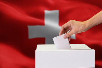 Close-up of human hand casting and inserting a vote and choosing and making a decision what he...