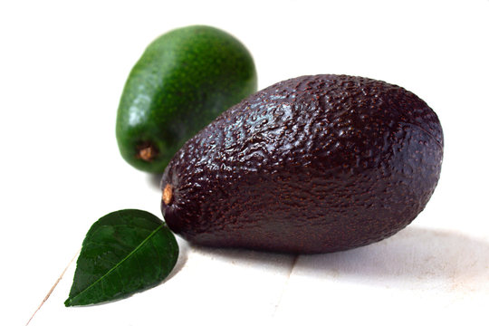two large ripe brown with green avocado fruit close on the table