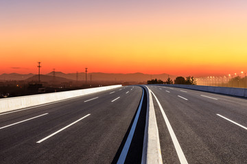Asphalt road and hills at beautiful sunset