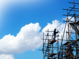 Construction workers working on scaffolding, Man Working on the Working at height with blue sky at construction site