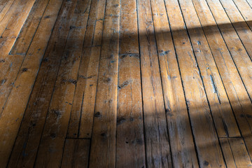 Old wooden floor background and sun rays on the boards.